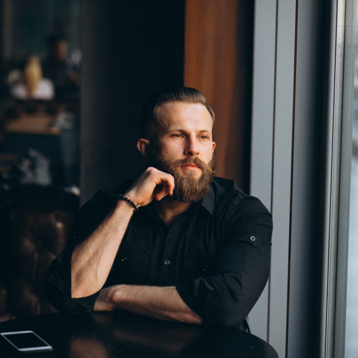 Nicely groomed man with a short beard sitting at an office table