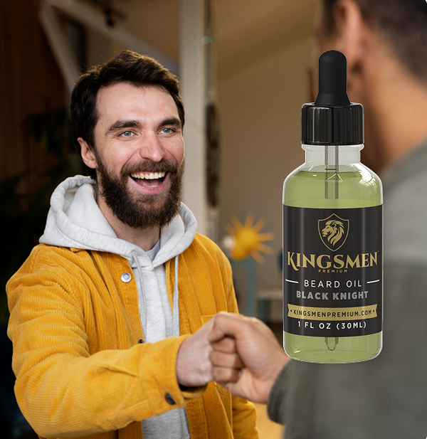 A man in a yellow jacket and white hoodie fist-bumps another person while a bottle of Kingsmen Beard Oil Black Knight is shown prominently on the right against a blurred indoor background.-mobile