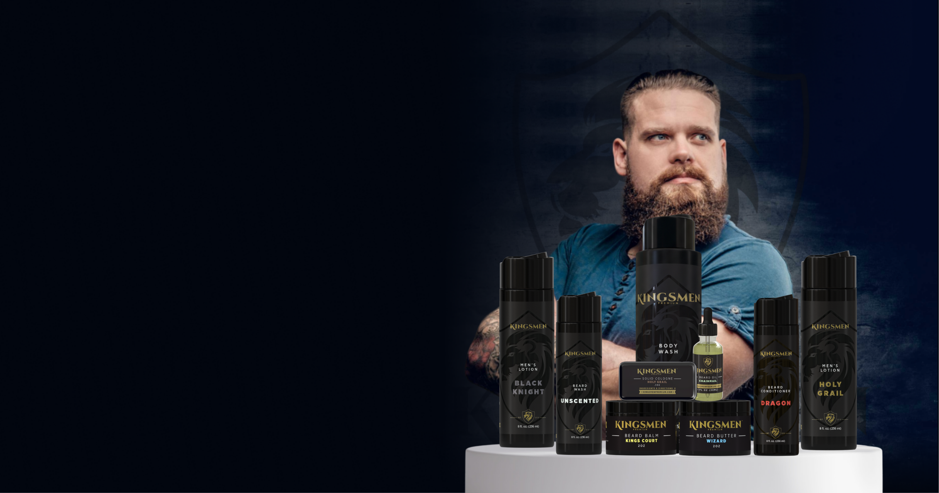Man with a beard standing behind a display of black bottles on a dark background