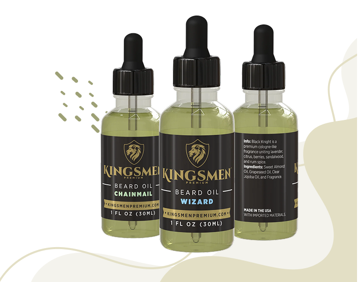 Three small dropper bottles of Kingsmen beard oil in different scents (Beardchainmail, Beard Oil Wizard, and Beard Alchemist) arranged on a white background with abstract beige shapes.